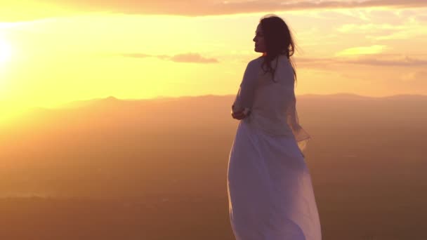 Mujer solitaria contra una hermosa puesta de sol — Vídeos de Stock