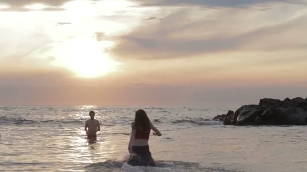 Влюбленная одетая женщина бежит к своему мужчине в море - объятия и поцелуи - закат — стоковое видео