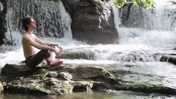 Депрессивный человек расслабляется на скале — стоковое видео