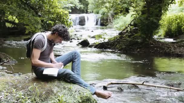 Hombre tomando notas sobre la naturaleza — Vídeos de Stock