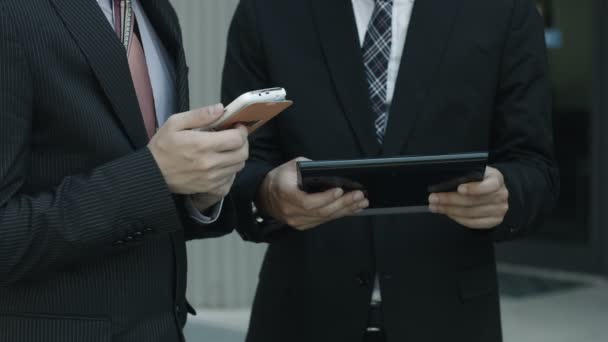 Podnikatel používá smartphone a tablet počítač s kolegy: týmová práce — Stock video