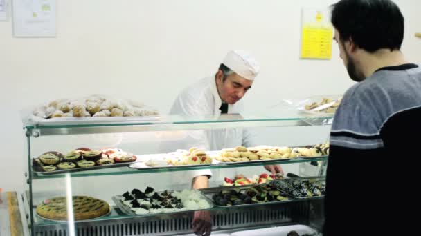 Boulanger vend des pâtisseries à un client — Video