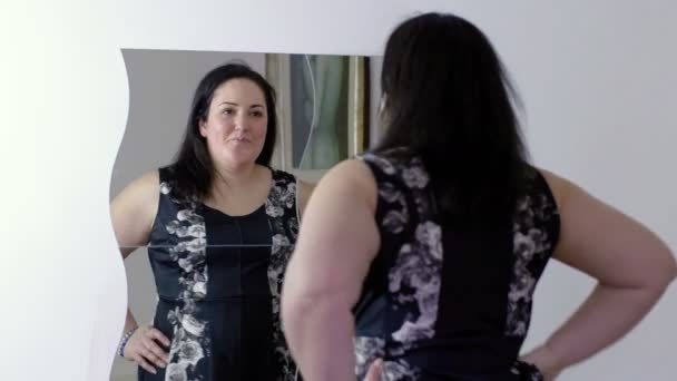 Överviktig kvinna som tittar i spegeln — Stockvideo