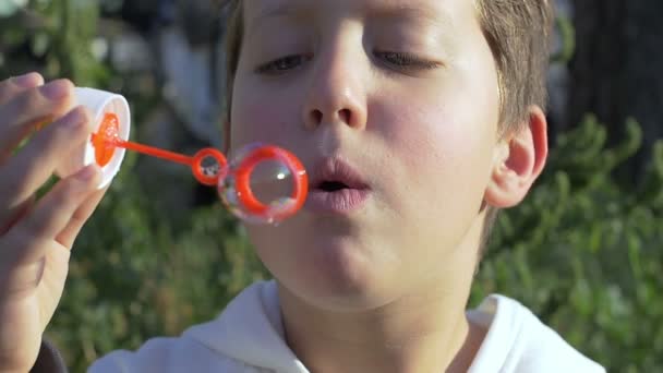 Niño haciendo soplador de burbujas: imágenes en cámara lenta — Vídeo de stock