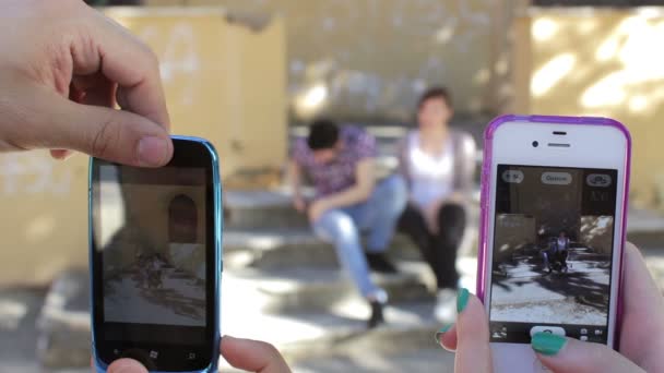 Två killar klantar sig gör roliga poser - mobiltelefoner - foto — Stockvideo