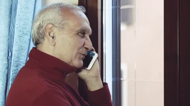 Anciano hablando con alguien con un teléfono inteligente moderno — Vídeos de Stock