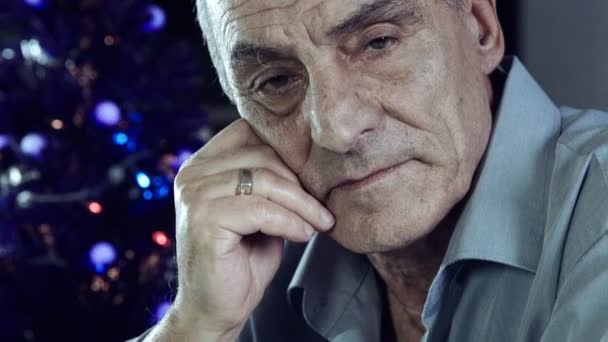 Porträt eines alten Mannes, der während der Weihnachtstage allein und deprimiert sitzt — Stockvideo