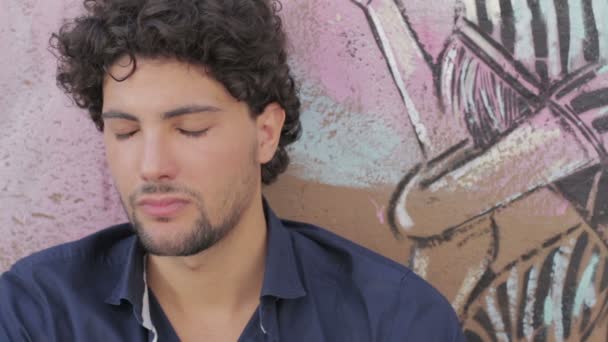 Trauriger Junge sitzt neben einer Graffiti-Wand — Stockvideo