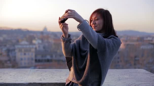 Woman taking self portrait in the terrace with Rome on background — Stockvideo