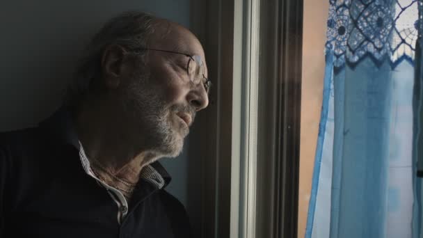 Старший чоловік дивиться на вікно — стокове відео