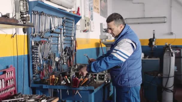 Auto mechanic repairing a part of a car engine — Stock Video