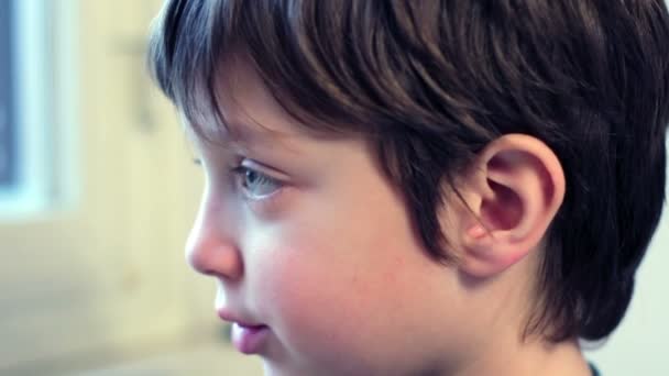 Beautiful child bored and sad looking through window — Αρχείο Βίντεο