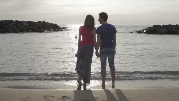 Deux amoureux courent après et s'embrassent dans la mer - plage - amour - coucher de soleil — Video