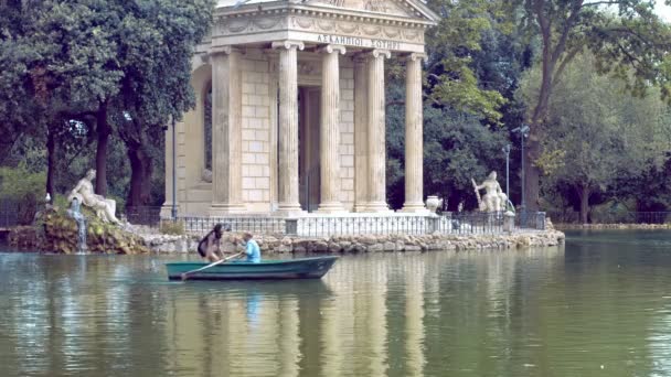 Pareja haciendo un recorrido romántico en bote de remos en la villa Borghese en Roma — Vídeo de stock