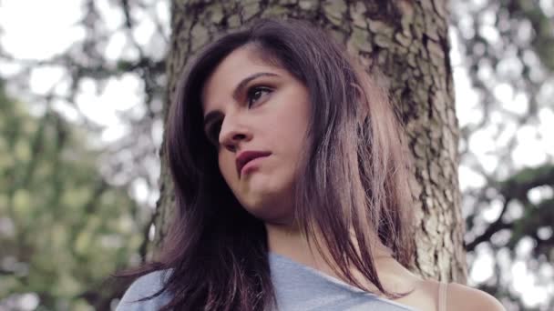 Samotna, młoda kobieta pochyla się na drzewie — Wideo stockowe
