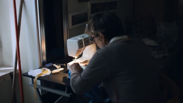 Mulher sênior trabalhando na máquina de costura em casa — Vídeo de Stock