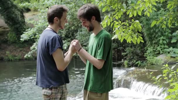 Двоє молодих геїв обіймають один одного — стокове відео
