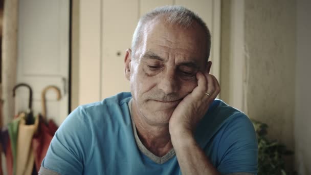 Smutny i przygnębiony starszy pan siedzi sama w domu: samotność, smutek, 4k — Wideo stockowe
