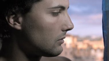 üzgün genç adam pencereden dışarı bakarak