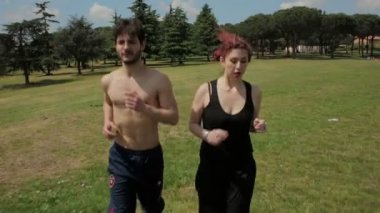Genç insanlar bir parkta vurulmuş steadycam çalıştıran fiziksel aktivite yapar