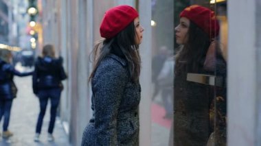 bir dükkan pencerede arayan kadın