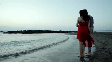 genç bir çift deniz güneş doğarken yakınındaki.