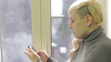 Düşünceli bir kadın yeni iPhone 'unu kullanıyor.