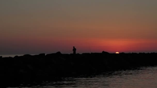 Fisherman fishing on the rocks — Stock Video