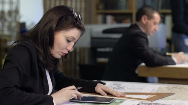 Trabalho em equipe em um estúdio de arquitetos: pessoas trabalhando em plantas e mapas — Vídeo de Stock