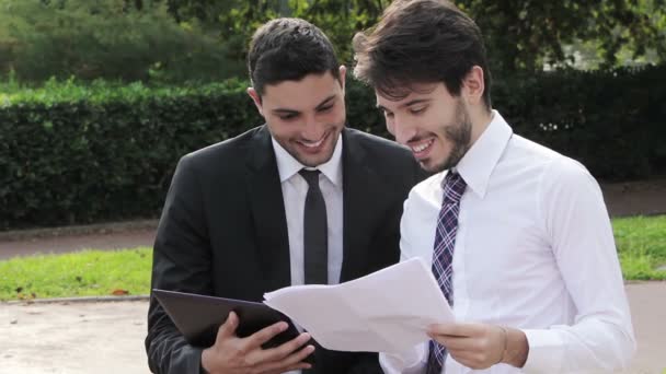 Dos hombres de negocios felices trabajando con la tableta — Vídeos de Stock