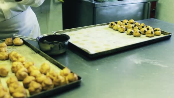 Pastry chef fills cream puffs — Stock Video