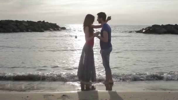 Coppia innamorata che balla e si bacia sulla spiaggia al tramonto - mare e amore — Video Stock