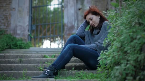 Young sad girl standing alone on staircase: sadness, upset, — Stockvideo