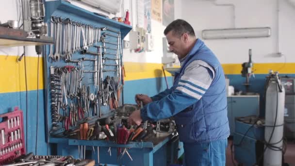 Mecánico de automóviles reparando una parte de un motor de coche — Vídeo de stock