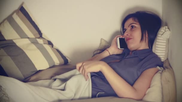 Mulher morena usar smartphone na cama no quarto em casa — Vídeo de Stock