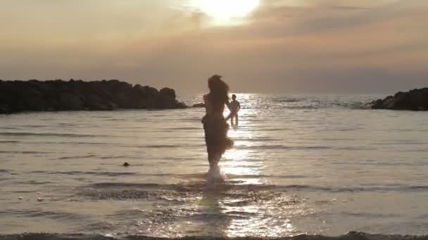 Chica enamorada corre a su novio en el mar - abrazos y besos - puesta de sol — Vídeos de Stock