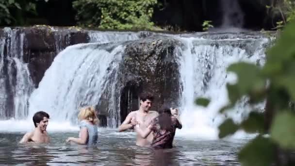 Девочки мальчиков веселятся в озере - танцуют, обнимаются и играют с водой — стоковое видео