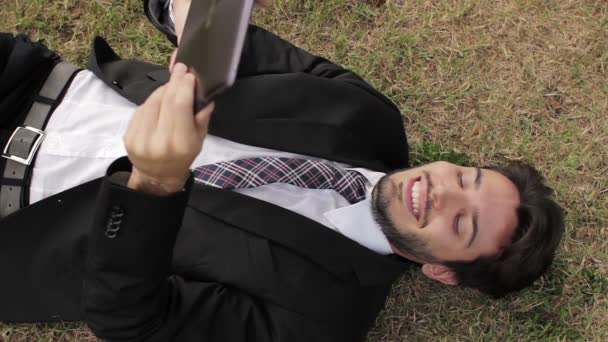 Hombre de negocios feliz que trabaja con la tableta PC en la hierba verde — Vídeo de stock