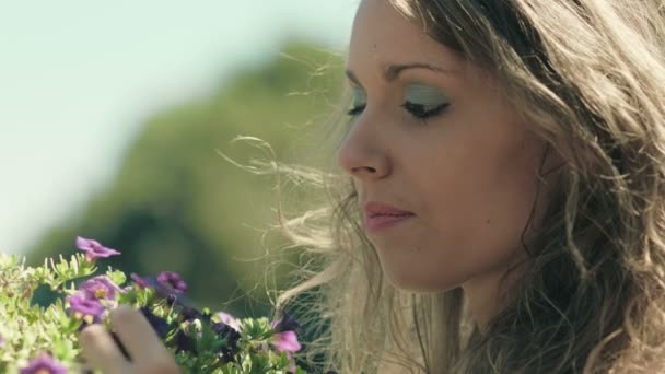 Nadenkend meisje raakt bloemen: doordachte meisje met een probleem in de liefde — Stockvideo