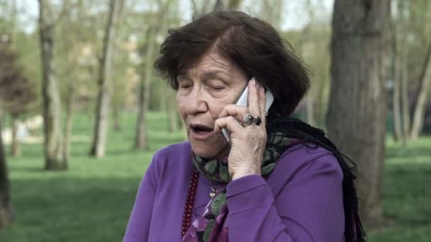 У старухи злобный и бурный телефонный звонок: сердитая пожилая женщина — стоковое видео