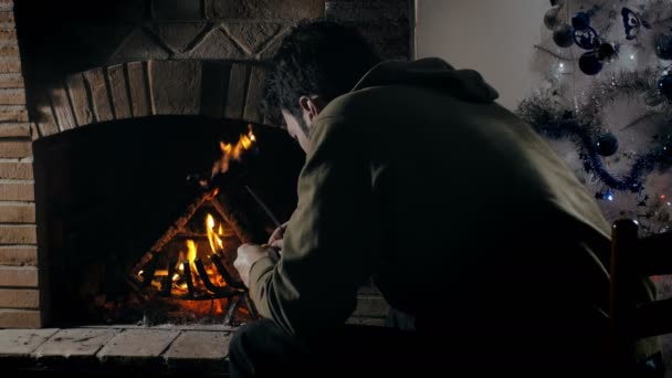 Tipo pensando delante de una chimenea — Vídeos de Stock