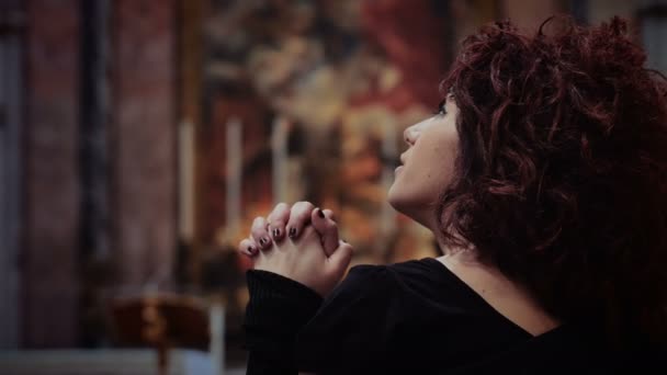 Сумна жінка молиться в церкві — стокове відео