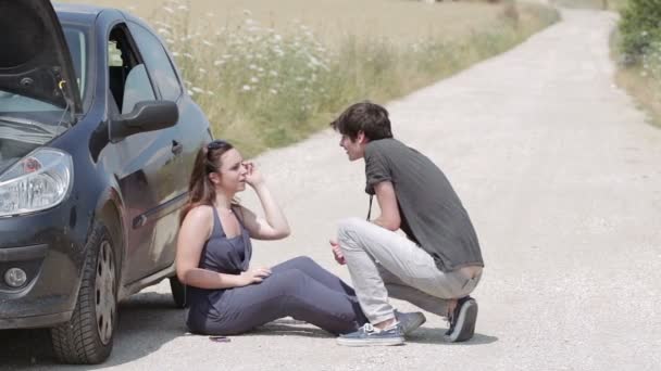 Man helps a woman with her broken down car — Stock Video