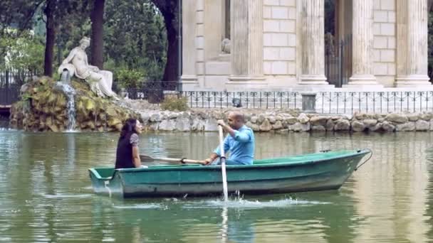 Mensen die een romantische reis op roeiboot in villa Borghese in Rome — Stockvideo