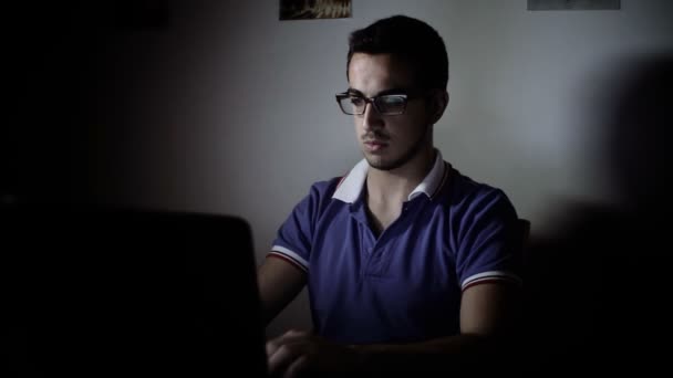 Young man using a laptop for chatting on facebook with friends — Stock Video