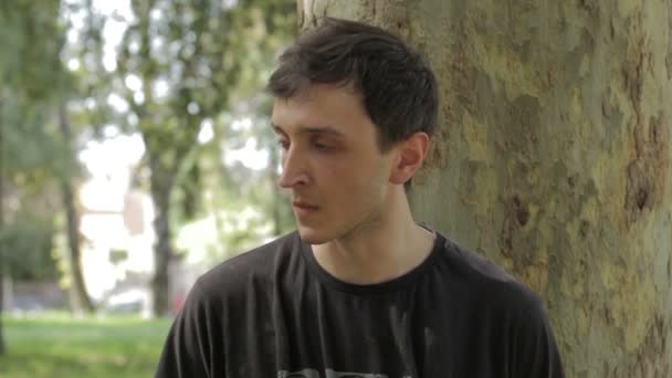 Angelägen ung man under ett träd — Stockvideo
