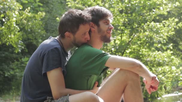 Dva mladí muži flirtování na slunci. Gay scéna s jezerem na pozadí — Stock video