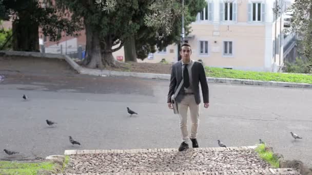 Gelukkig jonge zakenman spelen met duiven in de stad straat — Stockvideo