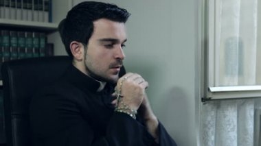 Katolik rahip ile onun elinde tespih dua ediyor