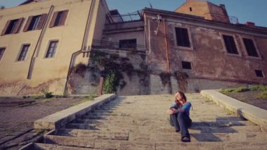 beautiful and pensive tourist woman relaxes in stairs in rome